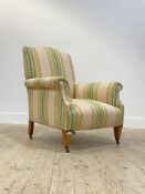 An Edwardian easy chair, upholstered in striped gilt and green cotton, standing on square tapered