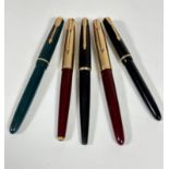 A group of five various Parker fountain pens including a green plastic fountain pen, a maroon gold