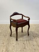 An Edwardian mahogany piano stool, with shaped back and elbow rest, velvet covered seat opening to