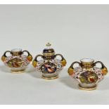 A set of three Crown Derby black stamp mark squat twin handled vases, one complete with domed cover,