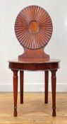 A George III mahogany hall chair in the manner of Mayhew and Ince, late 18th century, the oval fan