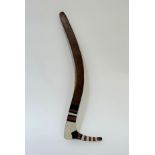 An Australian Aborigine hooked boomerang, with painted decoration, bands of black, white and red