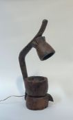 An unusual table lamp formed from African carved wooden mortars. Height 75cm
