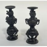 A pair of Japanese patinated bronze candlesticks, Meiji period, late 19th century, each of double