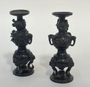 A pair of Japanese patinated bronze candlesticks, Meiji period, late 19th century, each of double