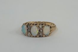 An Edwardian opal and diamond ring, the three graduated oval cabochon opals spaced by two rows