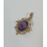 An Edwardian amethyst and seed pearl brooch / pendant, the oval-cut amethyst within a beaded band,