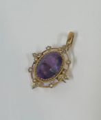 An Edwardian amethyst and seed pearl brooch / pendant, the oval-cut amethyst within a beaded band,