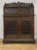 An Anglo Indian teak side cabinet, mid 19th century, the galleried top pierced and carved with