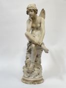 A Continental marble and alabaster figure of a pensive fairy, modelled seated on a rocky outcrop,