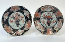 A pair of Japanese Imari porcelain plates, early 20th century, each centred by a flower-filled vase,