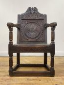 A 17th century stained oak wainscot chair, possibly Welsh, the scroll carved crest rail above a