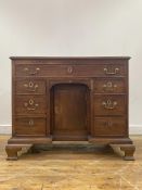 A George III mahogany knee hole desk, late 18th century, the top of rectangular outline over one