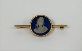 A 9ct gold bar brooch, centred by a an earlier blue jasperware cameo plaque of the bust of an 18th