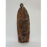 A painted wooden wall mask, Papua New Guinea, with cowrie shell eyes. Height 41cm