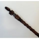 A Chokwe, Angola, carved wooden staff, with crouching figural terminal over a shaft carved in relief