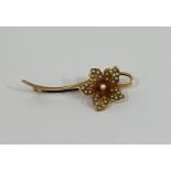 A 15ct gold and seed pearl floriform brooch, the petals set with seed pearls on a knife edge bar