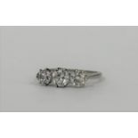 A three-stone diamond ring, probably c. 1930, the three round brilliant-cut graduated stones claw-