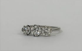 A three-stone diamond ring, probably c. 1930, the three round brilliant-cut graduated stones claw-