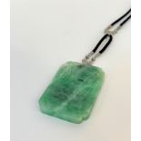 A striking diamond and jadeite pendant in the Art Deco taste, c.1930, the rectangular jadeite jade