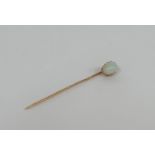 An opal stick pin, early 20th century, the oval cabochon opal claw-set on a gold (unmarked) pin.