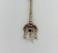 A ruby and baroque seed pearl pendant, of Indian design, suspending three pearl drops in (