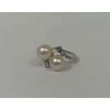 A cultured pearl and diamond dress ring, centred by twin cultured pearls in a crossover setting