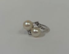 A cultured pearl and diamond dress ring, centred by twin cultured pearls in a crossover setting