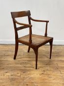 A Regency period yew wood elbow chair, the crest rail inlaid with ebony bands, above reeded open