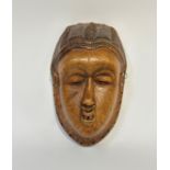 A southern African carved wooden mask, possibly Chokwe, Angola, with almond eyes, parted mouth and