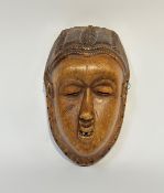 A southern African carved wooden mask, possibly Chokwe, Angola, with almond eyes, parted mouth and