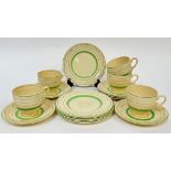 Clarice Cliff for Newport Pottery, a green painted and gilt part tea service comprising five cups (