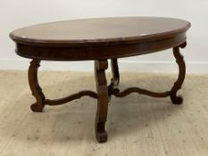 An Edwardian mahogany dining table of 18th century design, the oval top raised on s scrolled