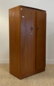 A mid century teak wardrobe, twin doors opening to shelves and a hanging rail, moving on castors.