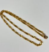 An Eastern style yellow metal spiral twist chain necklace with metal clasp fastening, unmarked (