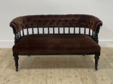 A Victorian Aesthetic design ebonised drawing room settee, the buttoned back on a spindle gallery,