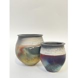 Two raku fired studio pottery vases decorated with white trailed decoration to the rim and an