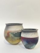 Two raku fired studio pottery vases decorated with white trailed decoration to the rim and an