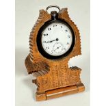 A treen Bavarian carved pocket watch folding stand of shaped design with carved panels to front,