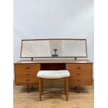 A mid century teak dressing table, circa 1960's, the arched rectangular mirror plate over a