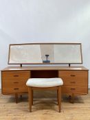 A mid century teak dressing table, circa 1960's, the arched rectangular mirror plate over a