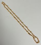 A 9ct gold fluted ball and open oval scrolling link 9ct gold chain necklace with lobster claw