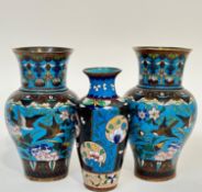 A pair of Meiji period Japanese cloisonne vases decorated with birds and flowers against a blue