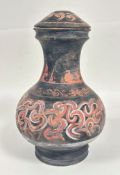 A pottery baluster jar and cover decorated with roman inspired scrolling design, on black ground (
