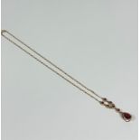 A 9ct gold chain link pendant necklace set pear shaped cognac garnet in rubover setting on