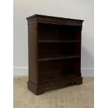 A Georgian style mahogany open bookcase, cross banded top over dentil cornice, two adjustable