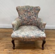 A late Victorian drawing room armchair, the serpentine back, arms and seat upholstered in cotton