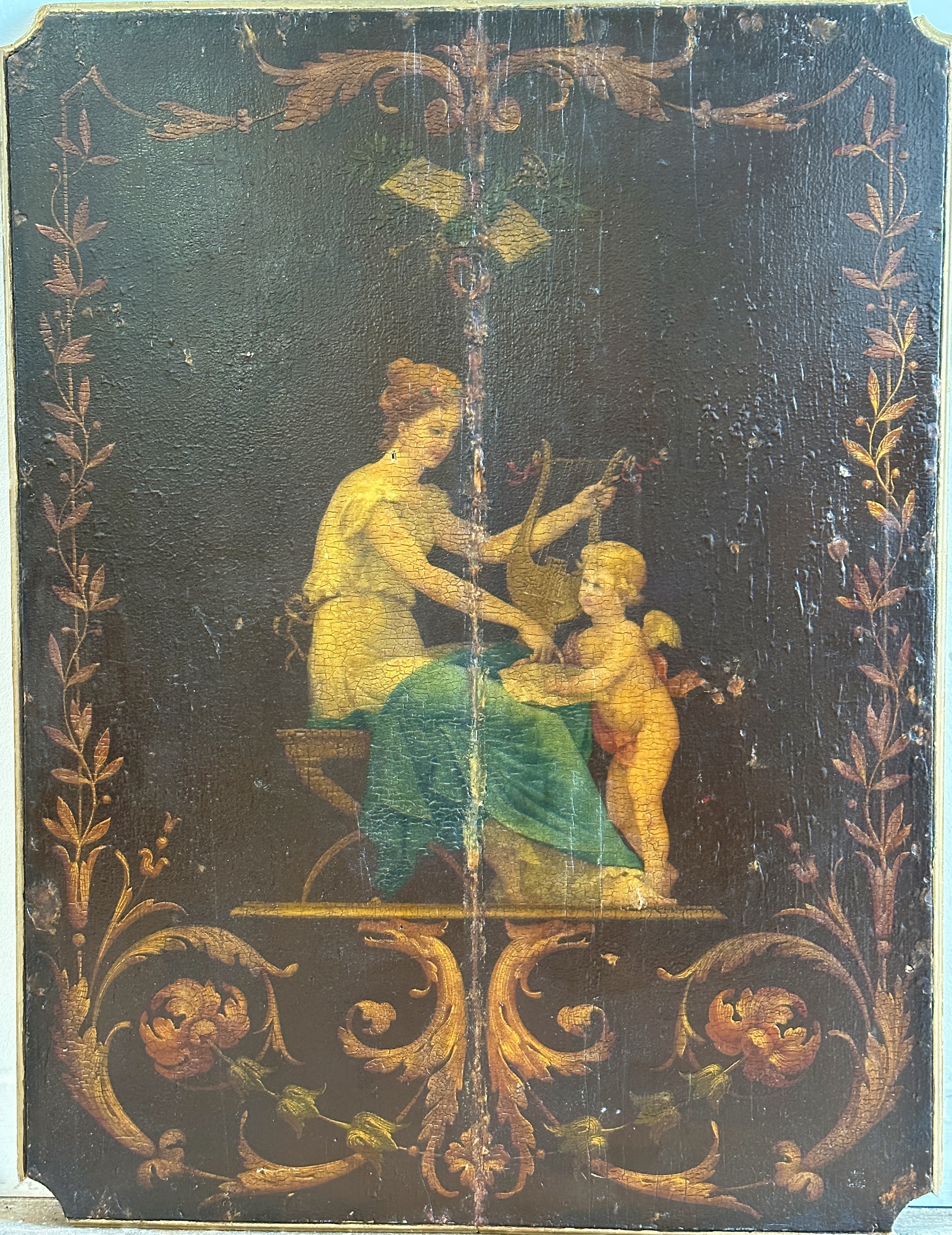A pair of Edwardian pine shaped panels with handpainted figures, Seated Maiden with Cherub, enclosed