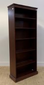 A Georgian style mahogany open bookcase, with dentil cornice over four adjustable shelves, raised on