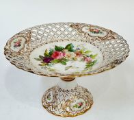 A gilt porcelain cake stand with enamelled rose decoration and pierced lattice design to the